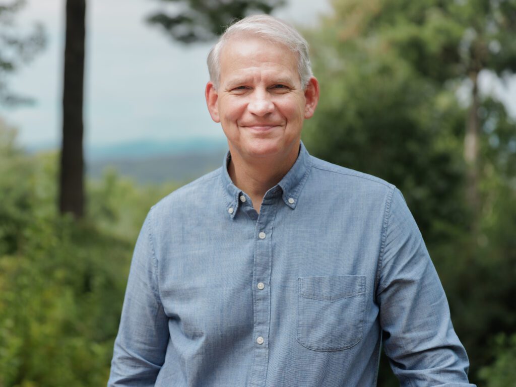 dr. richard hudspeth smiles outside near the mountains of asheville while exploring a run for congress